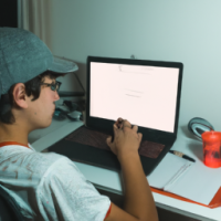 Un chico de 21 años estudiando Treding en su Mac desde el escritorio de su cuarto